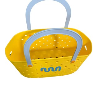 May include: A bright yellow tote bag with a light blue handle. The bag has a perforated design and a blue and yellow graphic on the side. The handles are light blue with orange accents. The bag is designed for carrying items.