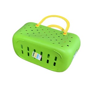 May include: A bright green plastic basket with a yellow handle. The basket has a rectangular shape with numerous small holes and vertical slots. A label is attached to the side.