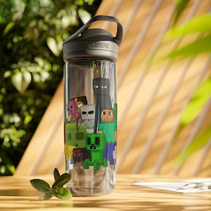 May include: A clear plastic water bottle with a grey lid and a black and green Minecraft character design. The bottle has the word "CamelBak" printed on the lid.