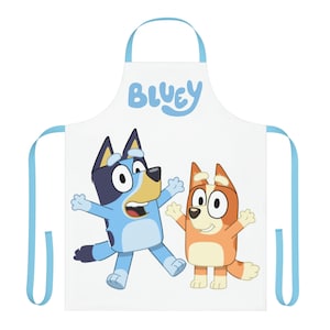 May include: A white apron with blue adjustable straps. The apron features a cartoon image of Bluey and Bingo from the children's television show Bluey. The text "Bluey" is printed in blue at the top of the apron.