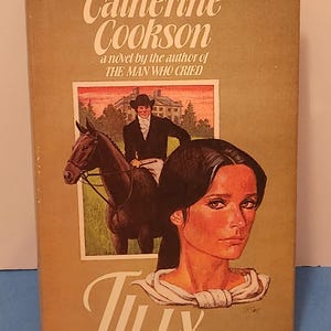 May include: A vintage book cover for "Tilly" by Catherine Cookson. The cover features a portrait of a woman with dark hair and a scene of a man on a horse. The title and author's name are in white script on a tan background.