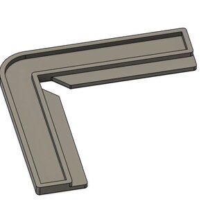 May include: A gray plastic corner brace with a right angle. The brace has a lip on the top and bottom edges.