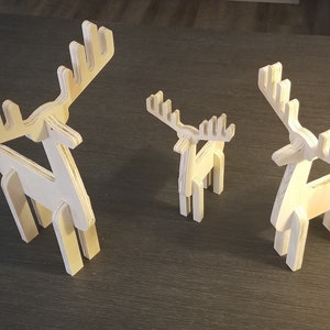 May include: Three wooden reindeer figurines of varying sizes. The largest reindeer is standing upright with its antlers raised. The medium-sized reindeer is also standing upright with its antlers raised. The smallest reindeer is standing upright with its antlers raised.