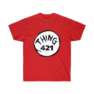 May include: Red t-shirt with a white circle and the text "THING 421" in black.