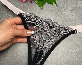 May include: Black lace underwear with a delicate floral pattern and a pink satin trim.