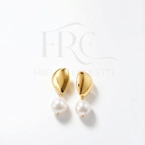 May include: A pair of gold-colored earrings with a teardrop-shaped top and a large, round, white pearl hanging below. The earrings are displayed on a white background.