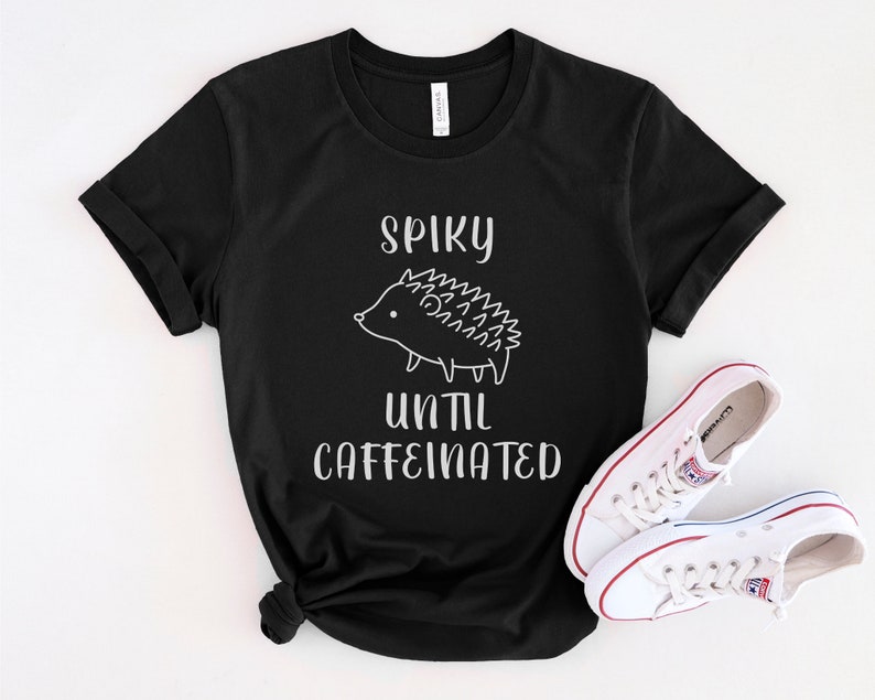 May include: Black t-shirt with a white graphic of a hedgehog and the text "Spiky until caffeinated".