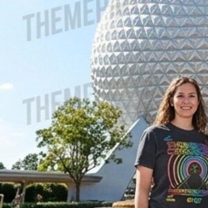 Puede incluir: Una camiseta gris oscuro de manga corta con un estampado gr&aacute;fico colorido de arcos de arco&iacute;ris conc&eacute;ntricos y una silueta de monta&ntilde;a con el texto "THUNDER MOUNTAIN" y "DISNEY" visible en el frente, frente a un gran domo geod&eacute;sico.