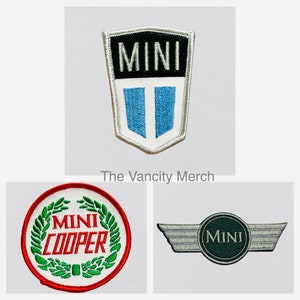 May include: Three embroidered patches featuring the Mini Cooper logo. The first patch is white with a blue and black Mini logo. The second patch is red, white, and green with the text "Mini Cooper" in a wreath. The third patch is silver with a green Mini logo.