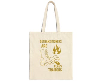 May include: Cream-colored tote bag with a gold graphic. The graphic includes the text "DETRANSITIONERS ARE CLASS TRAITORS" with an illustration of a boot and flames. The bag has two handles for carrying.