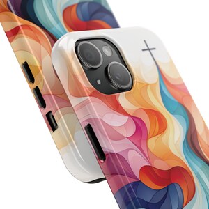 May include: A white phone case with a colorful abstract design and a cross symbol. The case is made of a hard plastic material and has a raised lip around the camera lens to protect it from scratches.
