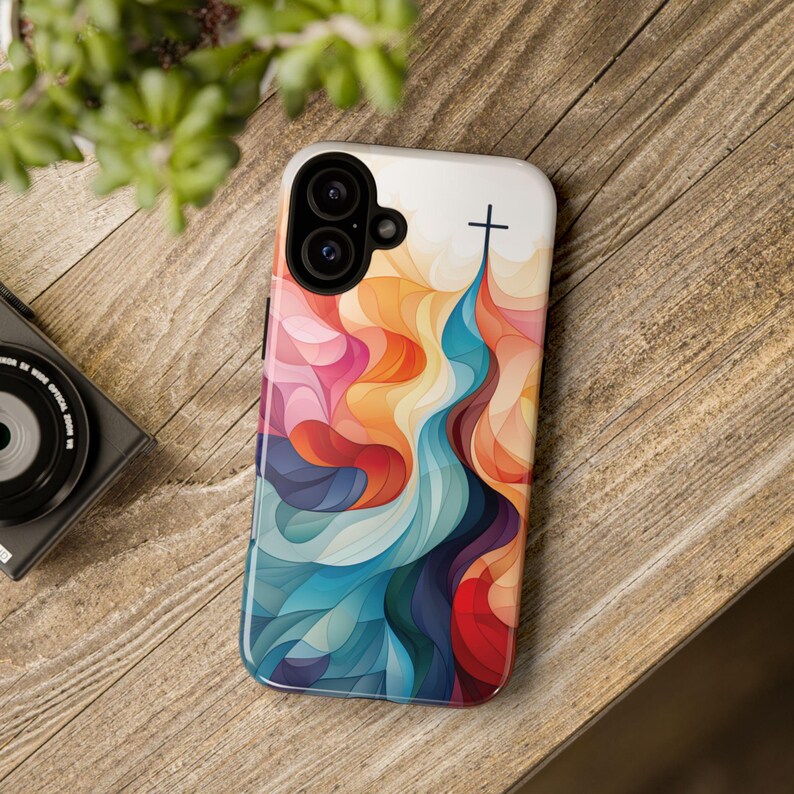 May include: A colorful phone case with a cross design. The case features a swirling pattern of blue, red, orange, and yellow. The cross is black and is located at the top of the case.