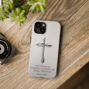 May include: White phone case with a silver cross and the text "NO WEAPON FORMED AGAINST ME SHALL PROSPER Isaiah 54:17"