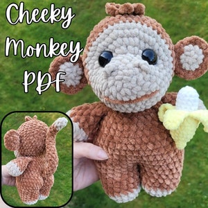 May include: A crocheted monkey toy holding a yellow banana. The monkey is brown with a beige face and has black eyes. The toy is made with a soft, fuzzy yarn. The text "Cheeky Monkey PDF" is visible in the background.