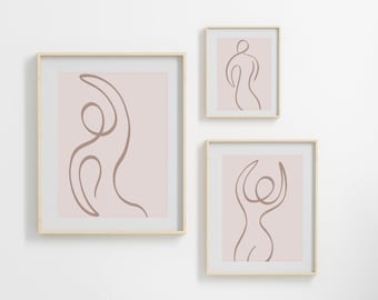 May include: Three framed prints with a minimalist line drawing of a person in a brown color on a light pink background.