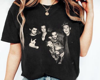 Könnte beinhalten: Schwarzweißfoto von fünf Männern auf einem schwarzen T-Shirt. Die Männer lächeln alle und schauen in die Kamera. Das T-Shirt ist ein beliebter Stil für Fans der Band.
