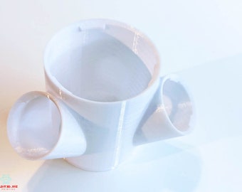 Peut inclure: Une tasse blanche imprimée en 3D avec trois ouvertures. La tasse est conçue pour contenir plusieurs objets, tels que des stylos, des crayons ou d'autres petits objets.