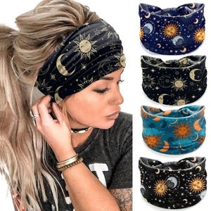 以下が含まれることがあります： 太陽、月、星のデザインが施された黒い天体プリントのヘアバンドを着用している女性。画像には、ネイビー、ブラック、ティールカラーの同様の天体模様のヘアバンドが3つ表示されています。これらのヘアバンドはファッションアクセサリーです。