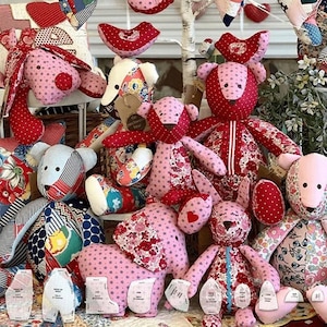 Può includere: Una collezione di animali di peluche fatti a mano realizzati con vari tessuti a fantasia, tra cui pois rossi, stampe floreali e tessuti a righe. L'assortimento comprende diversi orsi e altre creature con dettagli cuciti e cartamodelli di carta.