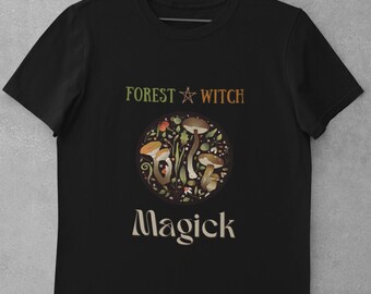 May include: Black t-shirt with a white graphic of a circle with mushrooms and leaves. The text "Forest Witch Magick" is printed in white on the shirt.