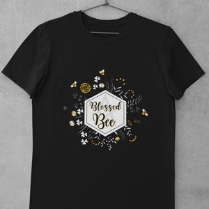 May include: Black t-shirt with a white hexagonal graphic that says "Blessed Bee" surrounded by yellow and white flowers and bees.