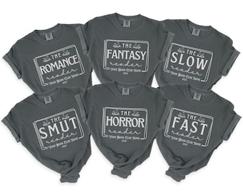 May include: Eight gray t-shirts with white text. Each shirt features a different book genre with the text "The [genre] reader" and "Your Book Club Name 2024". The genres are Romance, Fantasy, Slow, Smut, Horror, and Fast.