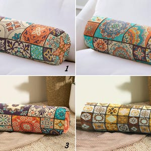 May include: Four decorative bolster pillows with a patchwork design. Each pillow features a cylindrical shape and is covered in a fabric with a repeating pattern of colorful, geometric tiles. The color palette includes shades of orange, blue, yellow, and brown.