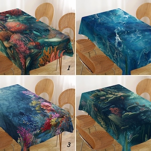 Op de afbeelding: Vier rechthoekige tafelkleden met onderwaterrifontwerpen. Elk tafelkleed heeft een andere oceaanscène met koraal, vissen en verschillende tinten blauw, groen en rood. De tafelkleden zijn over houten tafels gedrapeerd.