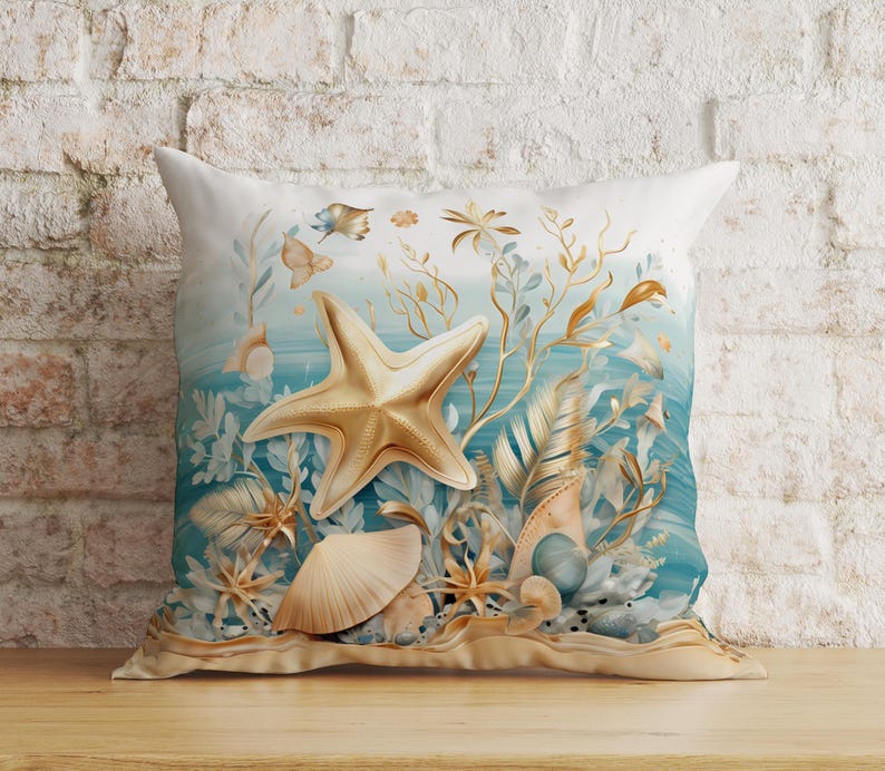 Puede incluir: Un coj&iacute;n cuadrado con un dise&ntilde;o estampado de una gran estrella de mar dorada, varias conchas marinas y algas doradas delicadas sobre un fondo degradado en azul y blanco. La imagen representa una escena submarina con texturas suaves.