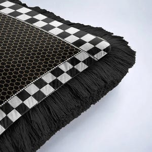 Puede incluir: Coj&iacute;n decorativo con un patr&oacute;n en blanco y negro y flecos. El coj&iacute;n presenta un dise&ntilde;o geom&eacute;trico con un patr&oacute;n de panal y un borde a cuadros. Los flecos negros a&ntilde;aden textura al dise&ntilde;o.