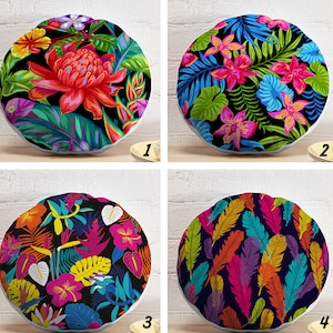 Pode incluir: Quatro almofadas redondas decorativas com desenhos florais e de penas tropicais. Cada almofada apresenta um padrão diferente: uma grande flor vermelha, orquídeas rosa, hibiscos coloridos e penas vibrantes. As almofadas estão sobre uma superfície clara.