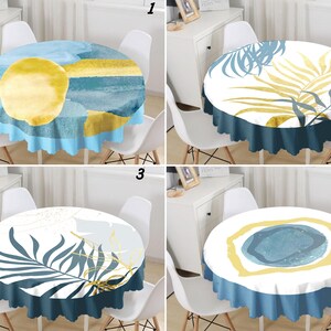 May include: A set of four round tablecloths featuring distinct abstract designs. The first shows a yellow circle on blue and teal layers. The second displays yellow and blue palm leaves. The third features blue palm leaves and gold lines. The fourth has a central blue circle with a yellow border.