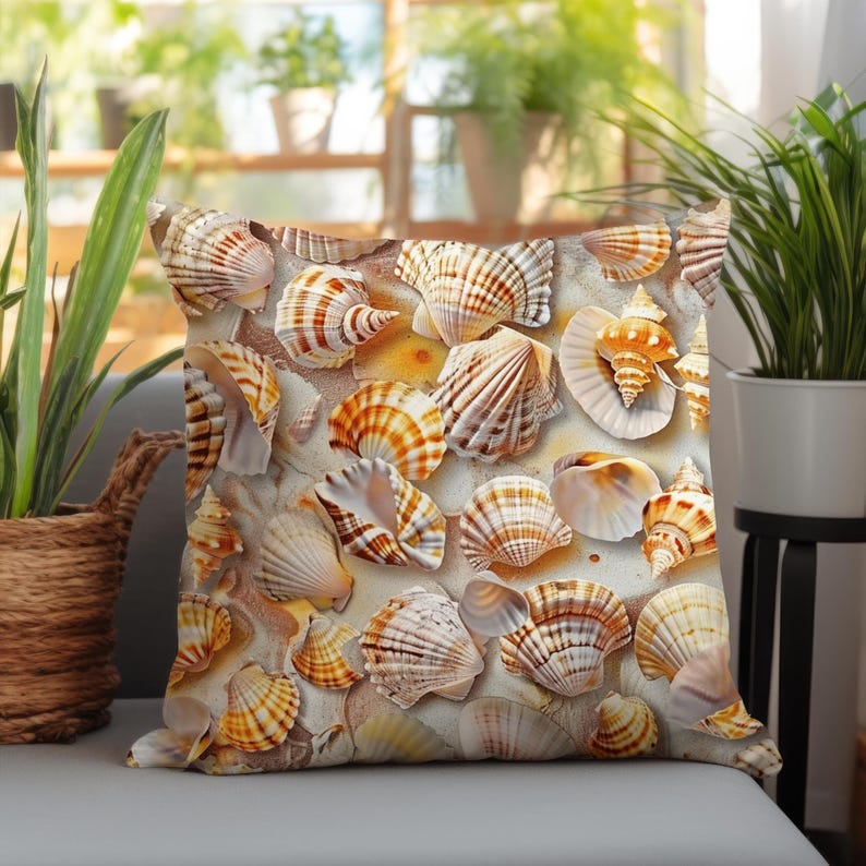 Puede incluir: Un coj&iacute;n cuadrado con un estampado detallado de varias conchas marinas en tonos bronceado, marr&oacute;n, naranja y blanco. El dise&ntilde;o muestra una colecci&oacute;n de conchas de caracola, vieiras y espirales dispersas sobre un fondo arenoso y texturizado.