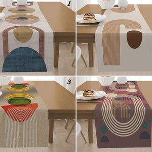 Op de afbeelding: Een set van vier rechthoekige tafellopers met abstracte geometrische patronen. Elke loper toont unieke arrangementen van cirkels, halve cirkels en gebogen lijnen in gevarieerde kleurenpaletten zoals blauw, bruin, rood, groen en kastanjebruin.