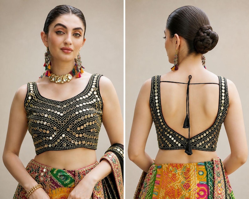 May include: A black sleeveless blouse featuring intricate gold-toned mirror work embroidery in a geometric pattern. The front has a scoop neckline, while the back features a deep scoop design with thin black tie-up strings and decorative tassels.