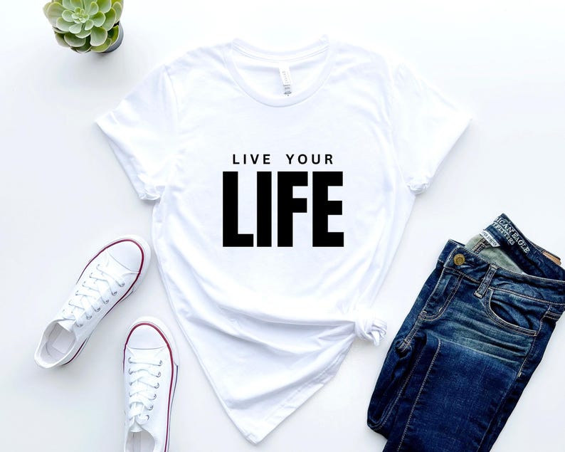 May include: White t-shirt with the text "Live Your Life" printed in black.