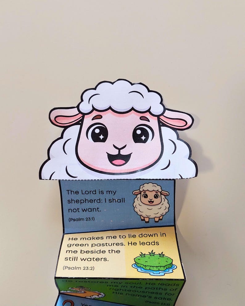 Puede incluir: Una colorida manualidad de papel de estilo caricatura con la cara de una oveja sonriente con un cuerpo blanco y esponjoso. La manualidad se despliega para revelar vers&iacute;culos b&iacute;blicos del Salmo 23:1 y 23:2, junto con ilustraciones.