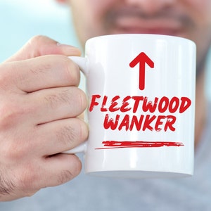 May include: White ceramic mug with a red arrow pointing upwards and the text "FLEETWOOD WANKER" in red.