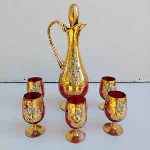 Juego de jarra veneciana de cristal de Murano y 6 vasos soplados a mano, pintados a mano con motivos florales y detalles dorados.
