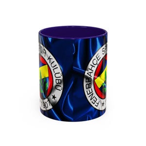 May include: A blue and white ceramic mug with a blue satin-like design. The mug features the Fenerbahçe Spor Kulübü logo, a yellow star, and the text "Fenerbahçe Spor Kulübü 1907".
