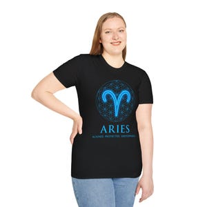 May include: Black t-shirt featuring a blue Aries zodiac symbol within a geometric design. The word "ARIES" is displayed below the symbol, with the text "ALIGNED. PROTECTED. UNSTOPPABLE." underneath. The shirt is a crew neck.