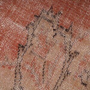 May include: Close-up of a woven rug with a geometric pattern in shades of brown, beige, and red.