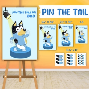 Op de afbeelding: Een blauw hondenpersonage met een zwarte vlek aan de zijkant danst op een blauw podium. Het personage komt uit de show Bluey. De afbeelding is een printbaar spel genaamd "Pin the Tail on Dad" en is verkrijgbaar in drie formaten: 24 inch bij 36 inch, 20 inch bij 30 inch en A3. Het spel bevat ook een set staarten om op de hond te prikken.