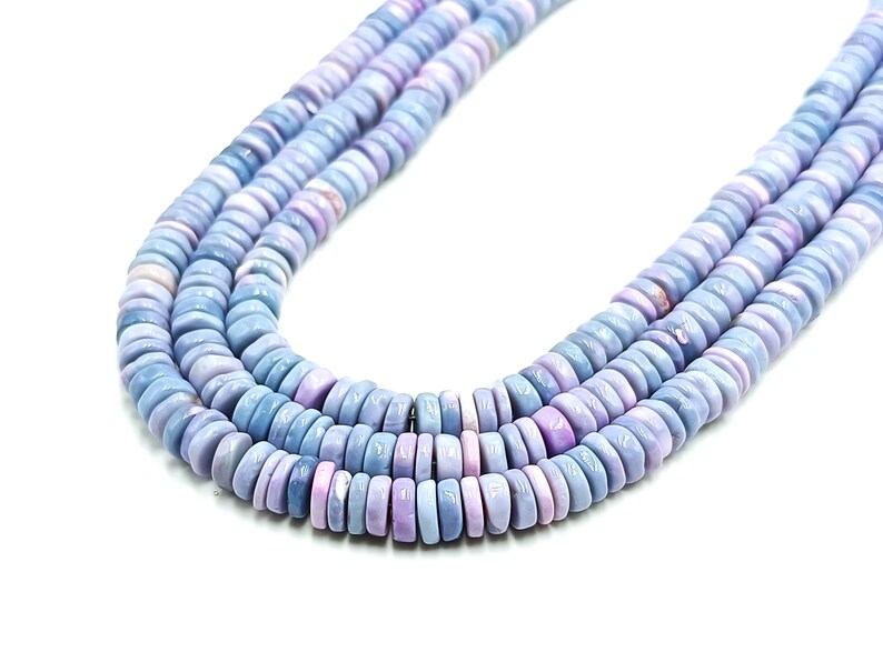 May include: Three strands of light blue and lavender gemstone beads. The beads are flat, round, and stacked together. The color gradient shifts from light blue to lavender and purple.
