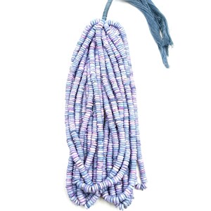 May include: A bundle of disc-shaped beads in shades of blue, purple, and white, tied together with a blue tassel. The beads are strung together, creating a cascading effect. The background is plain white.