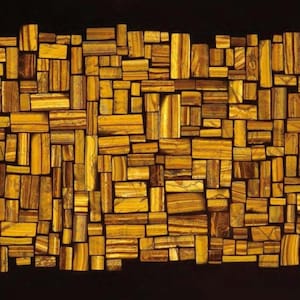 Könnte beinhalten: Abstrakte Kunstwerk aus zahlreichen rechteckigen Holzblöcken in verschiedenen Braun- und Goldtönen, angeordnet vor einem schwarzen Hintergrund. Die Blöcke sind unterschiedlich groß und ausgerichtet und erzeugen einen mosaikartigen Effekt.