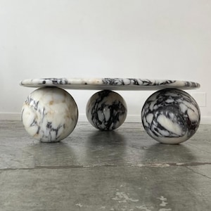 luxurious and elegant coffee table designed for the sophisticated bedroom. It features a round tabletop crafted from Calacatta Viola marble