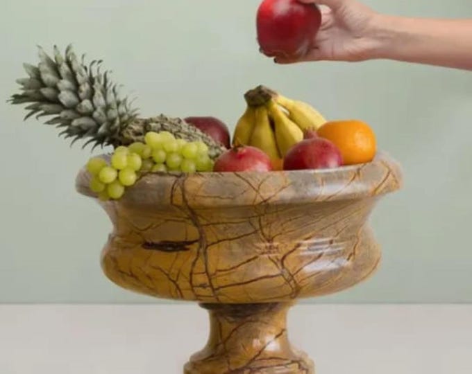 bowl and a gold-colored metallic base The bowl has a shallow