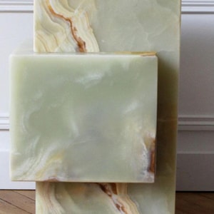 Modern green onyx marble block side tables with natural beige and cream veining.
