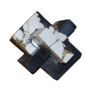 Könnte beinhalten: Ein schwarzes und weißes Marmorpuzzle in Form eines Kreuzes. Das Puzzle besteht aus vier Teilen, die ineinander passen.